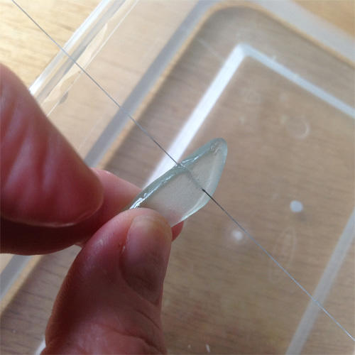 Diamond wire saw blade cutting a piece of seaglass