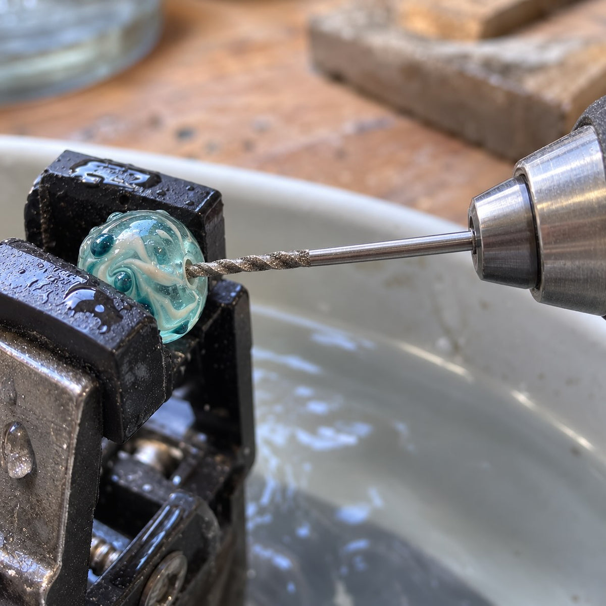 Diamond drill enters a lampwork glass bead