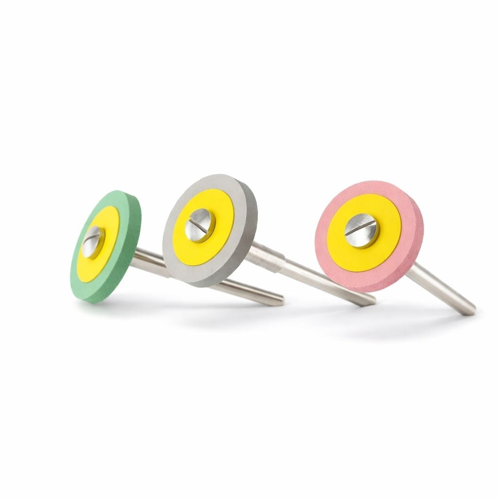 Three EVE Diapol diamond polishing wheels for polishing platinum, titanium and non-precious metals. Green, grey and pink wheels mounted on steel screw mandrels