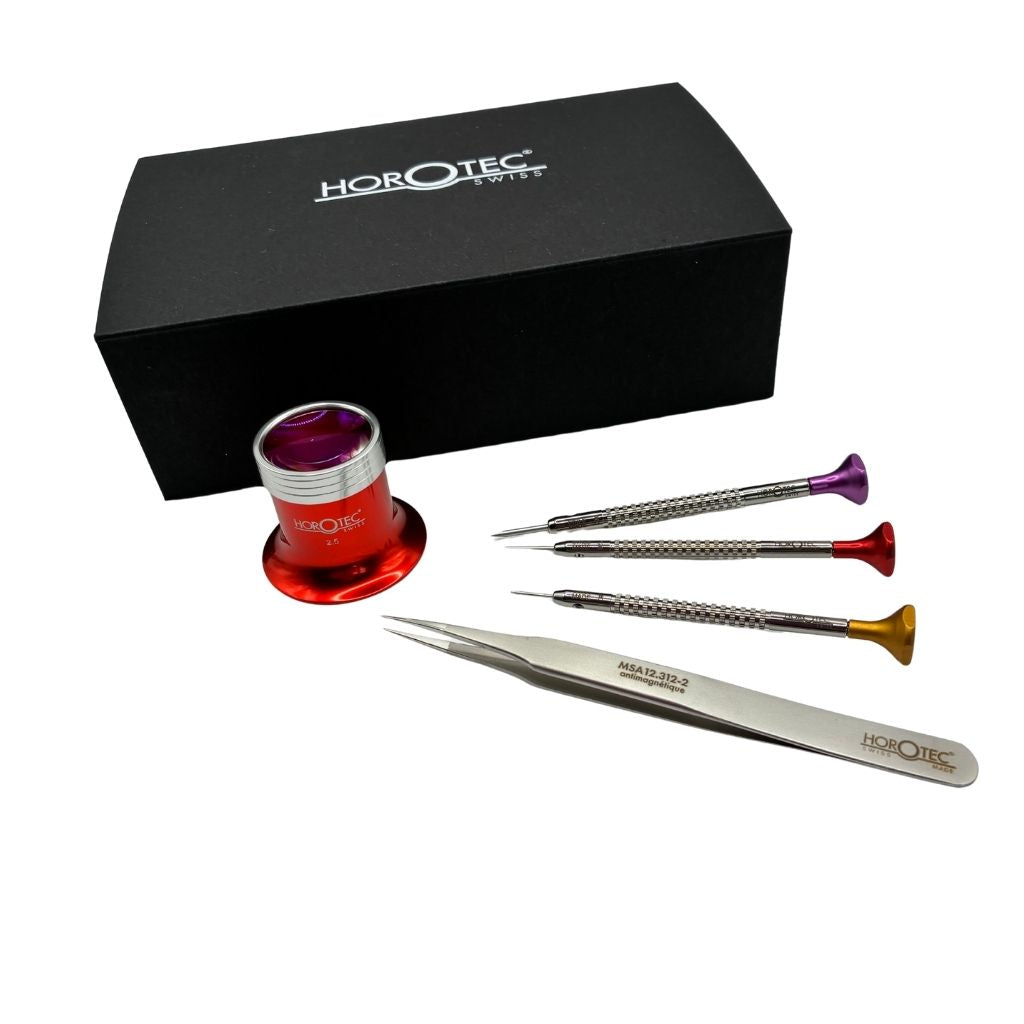 Horotec watchmaking kit with presentation box showing three screwdrivers, tweezers and a red eyeglass displayed together on white background