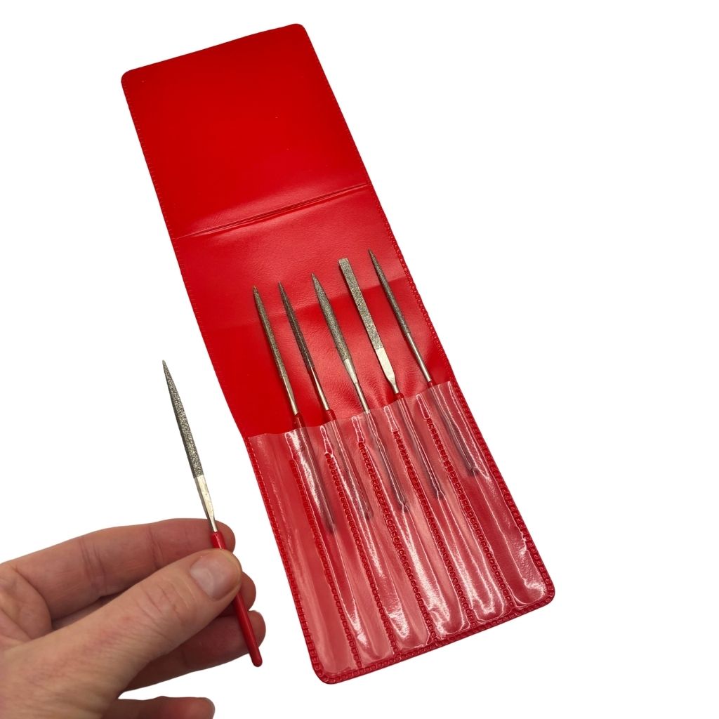 Mini diamond file set in a red storage sleeve, showing six files with red handles in individual pockets, with a hand holding one file for scale.